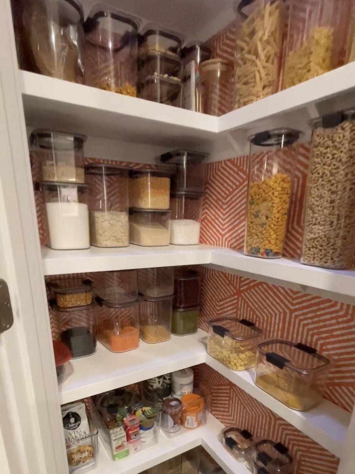 Small pantry remodel designed with colorful wallpaper and white shelves by Pragya Saikia Design in Reston, Virginia